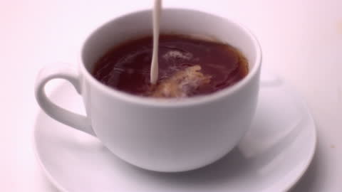 Pouring Milk into Freshly Brewed Tea Slow Motion