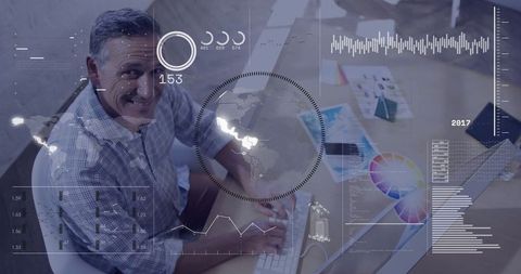 Smiling man analyzing data digital charts desk