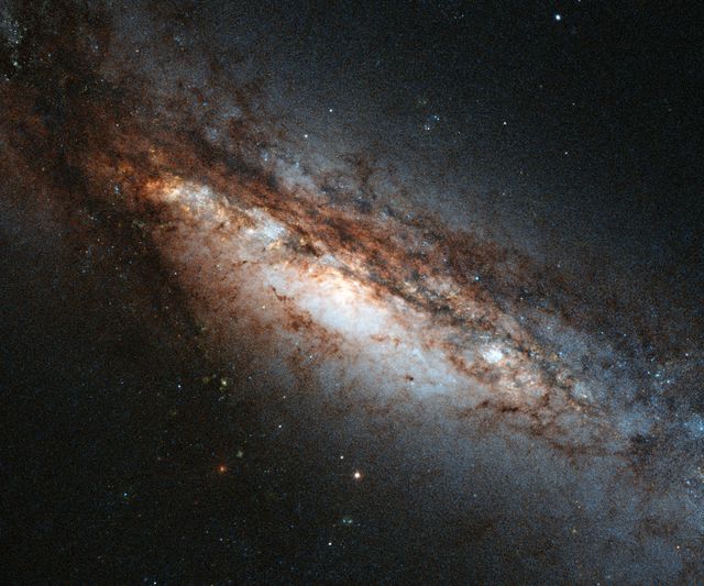 Peculiar galaxy NGC 660 located 45 million light-years away, captured by Hubble Space Telescope. Unique features include off-kilter central bulge and high amounts of dark matter. Image useful for astronomy education, space exploration articles, and cosmology research.