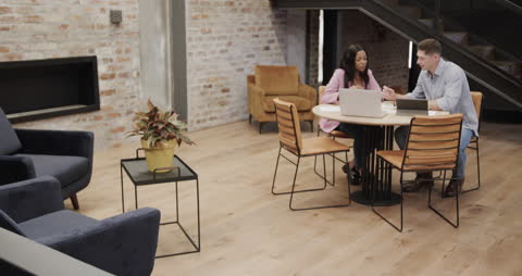 Colleagues in Modern Office Discussing Project at Laptop