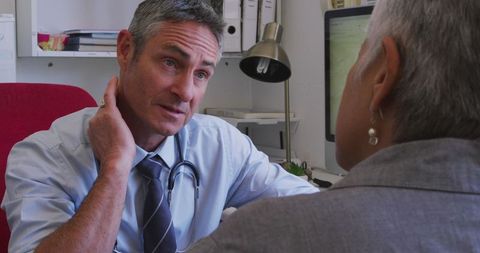 Doctor Advising Senior Patient on Treatment in Modern Clinic Office