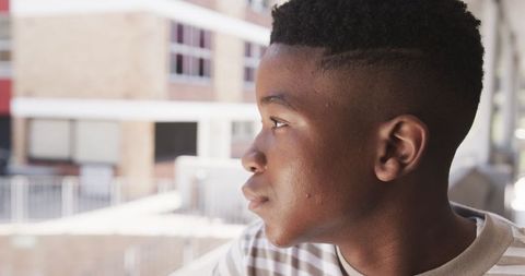 Urban Teen Boy on Balcony Observing Cityscape