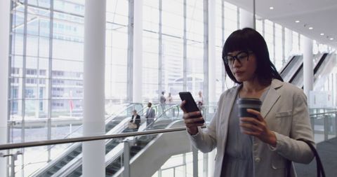 Businesswoman Using Smartphone in Modern Office Lobby - Download Free Stock Images Pikwizard.com
