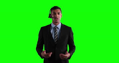 Businessman with Headset Communicating on Green Screen