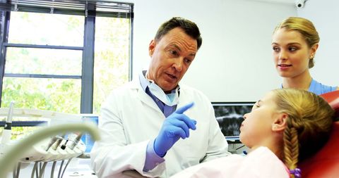 Dentist Discussing Procedure with Young Patient, Focus on Patient Comfort