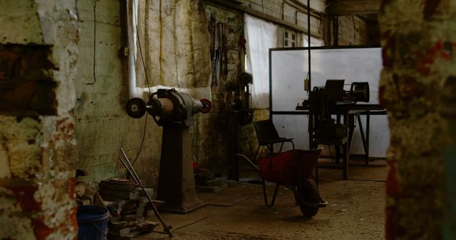 Old workshop featuring vintage tools and machinery, showcasing a rustic and industrial atmosphere. Ideal for concepts involving craftsmanship, history, abandoned places, or industrial aesthetic. Suitable for background use in design projects related to art, culture, and nostalgic themes.