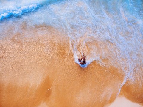 Aerial View of Ocean Waves Embracing Sandy Beach