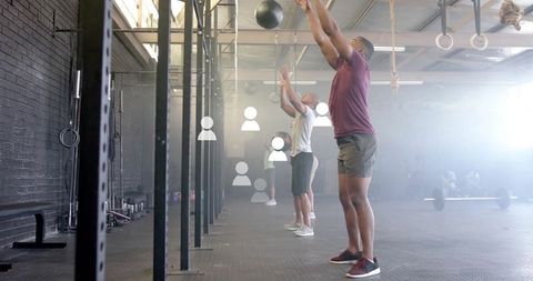 Athlete Engaging in Medicine Ball Wall Exercise at Modern Gym