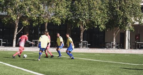 Soccer players practicing passing and defense on field
