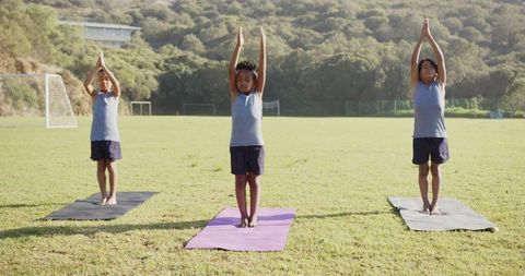 Diverse Boys Practicing Mountain Pose Outdoors on Sunny Day