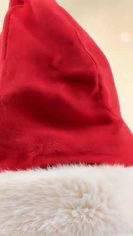 Vertical video zooming on red Santa hat revealing plush texture and fluffy white fur trim