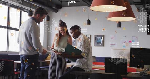 Multicultural team collaborating over tablet and documents in modern open-plan workspace