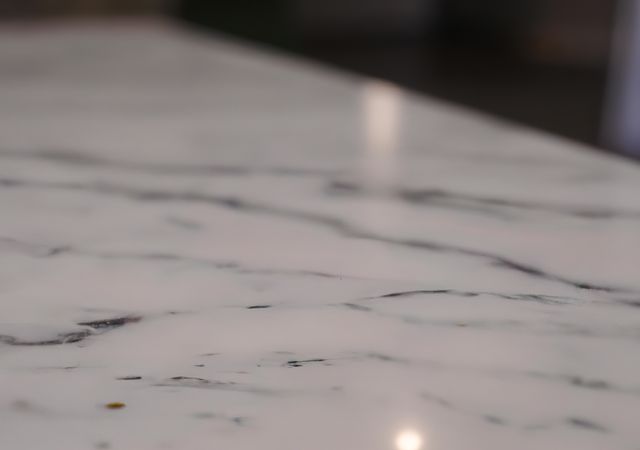 Close-up view of a marble surface showcasing subtle veining. Suitable for use in interior design concepts, architectural presentations, and materials for luxury products. Ideal for advertisements, home decor catalogs, and background textures in graphic design projects.