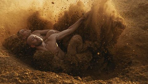 Sunlit Desert Wrestling Duo Throwing Up Dust in Dramatic Bare-Chested Sand Grapple Action