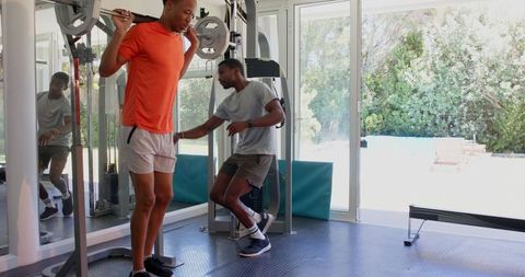 Man resting post-workout in home gym looking exhausted