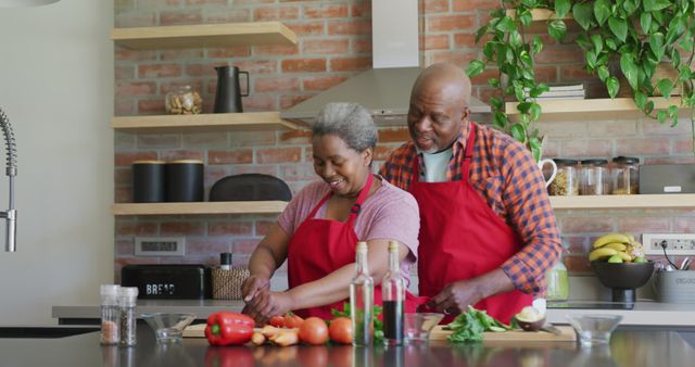 Happy african american senior couple cooking together in kitchen. retirement lifestyle relaxing and spending time at home.