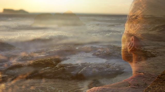 Video of a Caucasian woman relaxing by the ocean, overlaid with a scenic landscape containing sunset and rocky shoreline. The video exudes a sense of peace and calm, making it perfect for use in blogs, articles, or advertisements relating to nature, meditation, mental well-being, holidays, and relaxation.