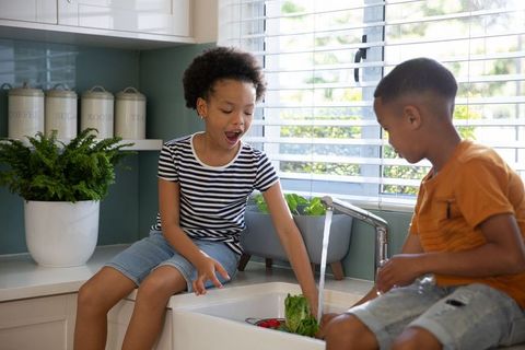 Diverse Siblings Enjoy Washing Vegetables at Kitchen Sink