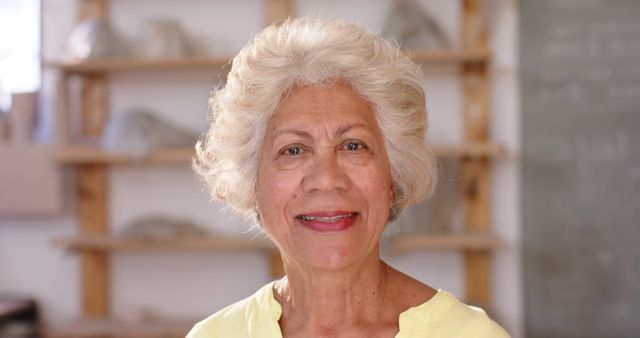 Smiling Elderly Woman in Workspace with Wooden Shelves Background - Download Free Stock Images Pikwizard.com