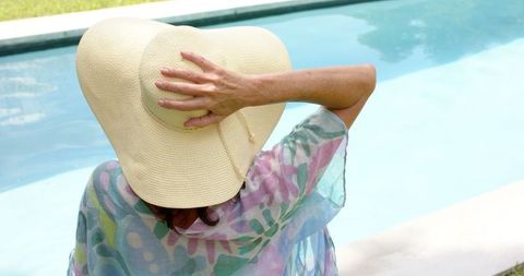 Woman Relaxing by Pool in Summer Floral Wear with Straw Hat - Download Free Stock Images Pikwizard.com
