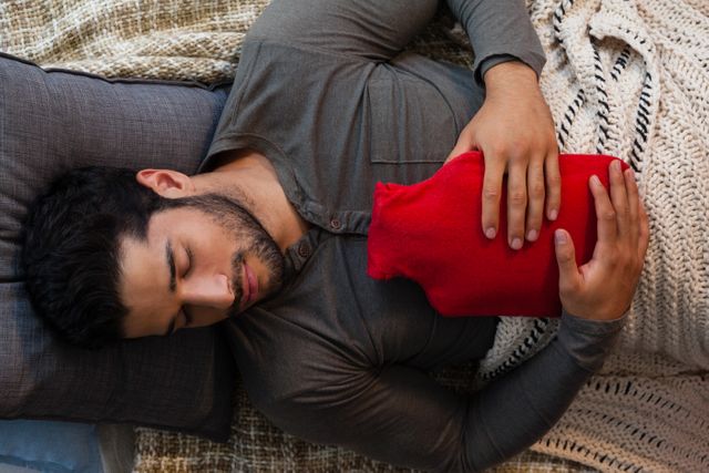Man sleeping with hot water bag at home
