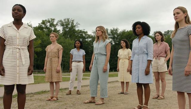 Diverse women standing on park path wearing summer dresses and sandals, casual outdoor portrait