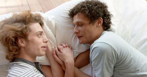 Joyful diverse gay couple enjoying intimate moment at home