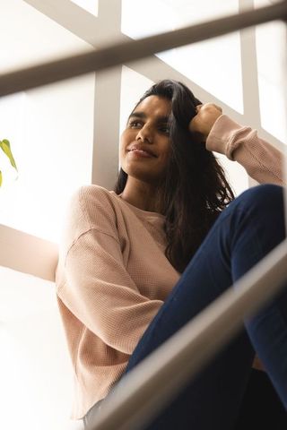 Contemplative woman relaxing in minimalist home environment