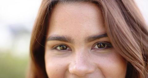 Smiling young african american woman with freckles and full brows closeup in natural light