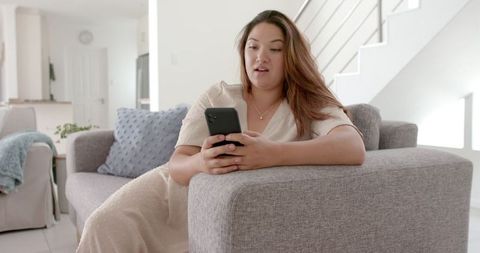 Content Biracial Woman Video Calling with Smartphone in Cozy Living Room