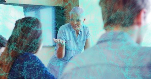 Mature woman leading workshop inviting participant input during collaborative training