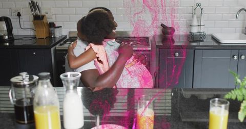 Father hugging daughter in modern kitchen with pink powder splash joyful family moment