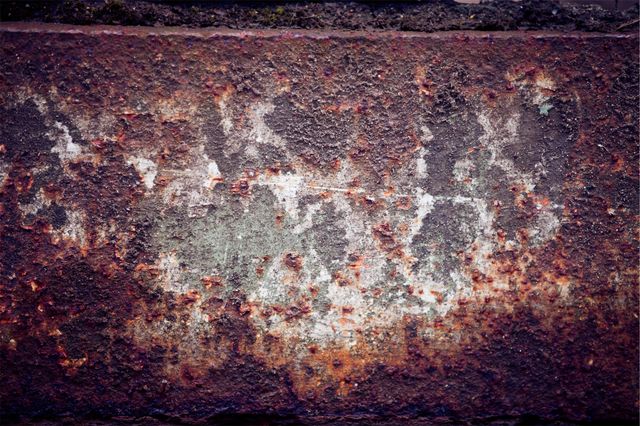 Close-up detail of rusty, weathered metal texture showing signs of corrosion and decay. Useful for backgrounds, design projects, or concepts related to aging and industrial elements. Ideal for artists looking for grunge textures or designers creating vintage or distressed graphics.