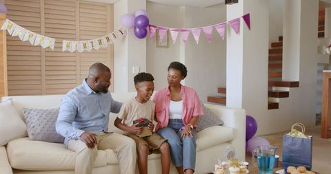African American Family Celebrating Son Birthday at Home with Gifts Balloons Cupcakes