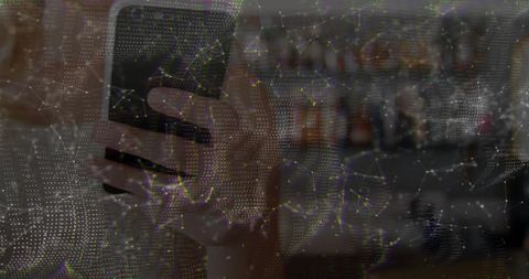 Hand holding smartphone in bar with digital network overlay
