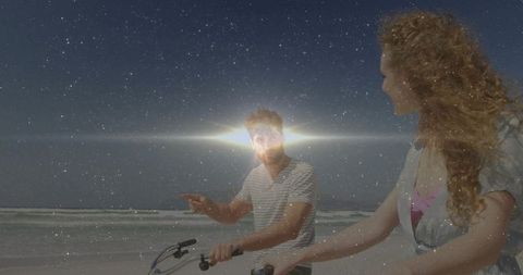 Couple Cycling on Beach Under Starry Sky at Dusk