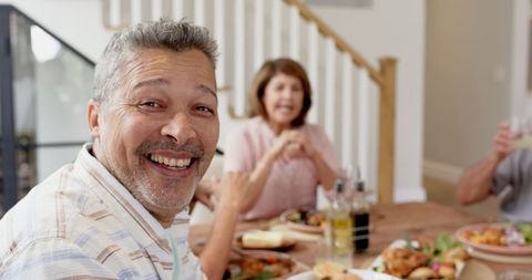 Laughing Senior Man Enjoying Dinner with Family at Cozy Home