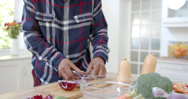 Person chopping vegetables on rustic wooden board in modern kitchen - Download Free Stock Images Pikwizard.com