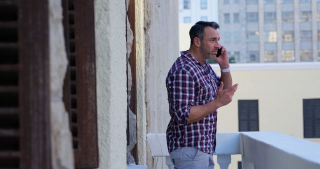 Middle-aged man speaking on smartphone on terrace - Download Free Stock Images Pikwizard.com