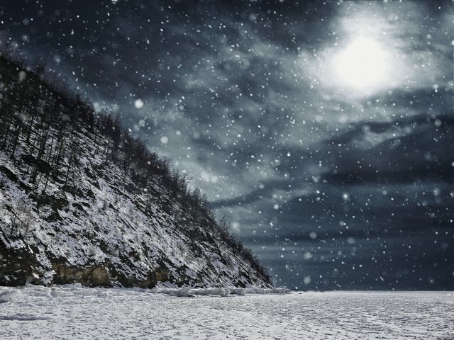 Moonlit snowfall illuminating mountain landscape at night, creating a tranquil and serene winter scene. Ideal for winter-themed backgrounds, nature wallpapers, outdoor adventure promotions, and holiday greeting cards.