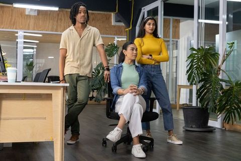 Multicultural young professionals collaborating in modern open-plan office with plants