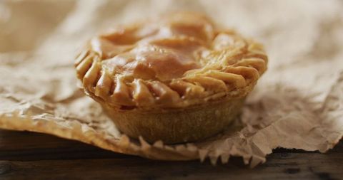 Golden savory pie on rustic wooden surface