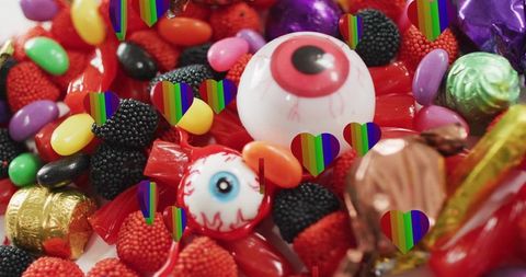 Vibrant halloween candy macro featuring eyeball gumball, wrapped treats and rainbow hearts