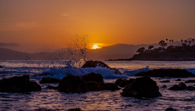 Vibrant Sunset Over Rocky Shoreline with Splashing Waves - Download Free Stock Photos Pikwizard.com