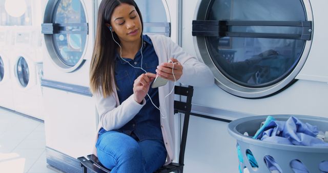 Woman Listening to Music While Waiting at Laundromat - Download Free Stock Images Pikwizard.com