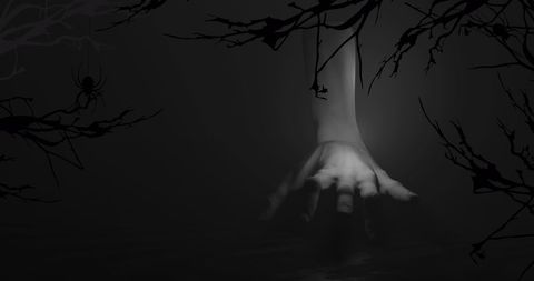 Creepy hand crawling in dark forest setting