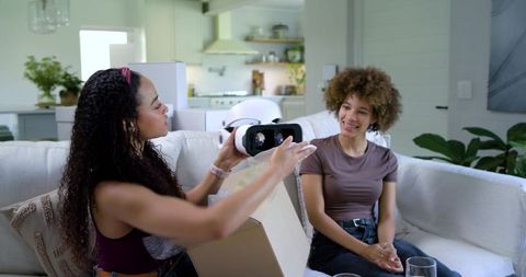 African American Friends Unboxing Virtual Reality Headset on Cozy Living Room Sofa