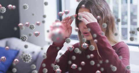 Woman sneezing visualized with virus particles indoors