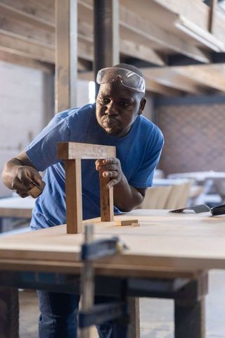 Skilled Carpenter Aligning Wood Joints on Bench in Workshop, Precision Woodworking