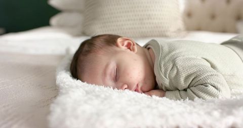 Peaceful Infant Sleeping on Soft Plush Blanket in Cozy Bedroom